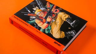 A photograph of a thick book on an orange background. The cartoon character on the front is holding a gun and is surrounded by stylized weapons.