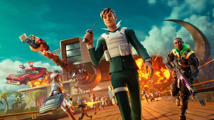A Fortnite promotional image showing a young man walking away from a mansion and pushing a button on a device as the mansion blows up behind him. A variety of other characters are racing away from the mansion as a number of masked people with guns and rifles shoot after them.