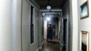 P.T. screenshot showing a somewhat grainy image of a realistic white hallway with a shadowed figure of a woman with an unnatural gait walking at the end of the hall
